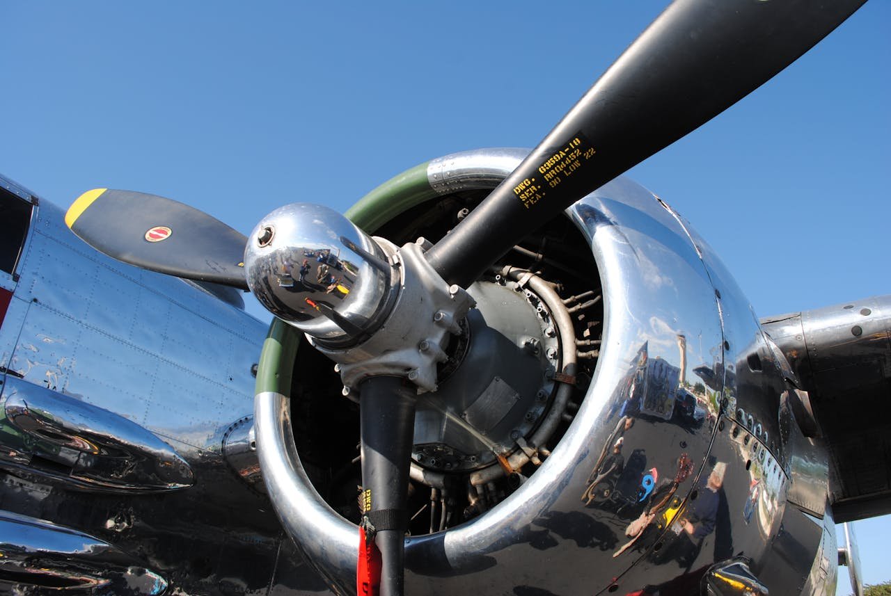 Detailed view of a polished airplane propeller and engine against a clear blue sky in Homestead, FL.